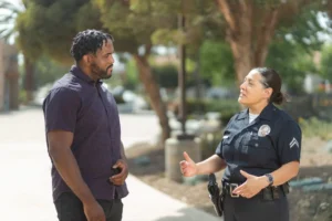 Can You Sue for Being Wrongfully Detained in California? 2 Police officer talking with a civilian on a city street.