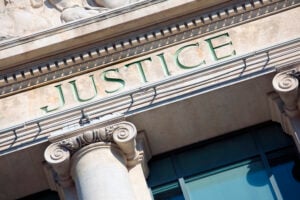 Who Investigates Police Misconduct and Who Pays for Police Misconduct Settlements? 2 Justice inscription on a courthouse building.