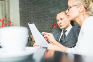 How Many People Are Needed for a Class Action Lawsuit? 1 Legal professionals reviewing case documents and discussing class action litigation strategy in a conference room.