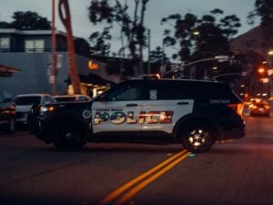 Can Police Search Your Car Without a Warrant in California? 1 Laguna Beach police SUV driving through an intersection at dusk.