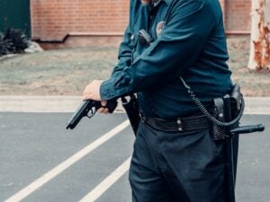 The Bane Act: California's Civil Rights Law and the Fight Over Intent 2 Police officer handling a handgun while standing in a parking lot.