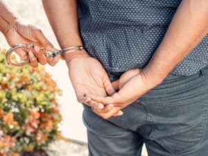 No Ticket, No Arrest, Still a Case: What a Wrongful Police Stop Is Worth 2 Police officer placing handcuffs on a man with his hands behind his back.