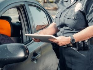 No Ticket, No Arrest, Still a Case: What a Wrongful Police Stop Is Worth 1 Police officer writing a citation beside a vehicle during a traffic stop.