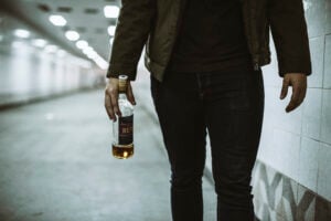 Is Being Drunk in Public a Crime in California? What Penal Code § 647(f) Really Requires 1 Person walking through a tunnel while holding a bottle of liquor.