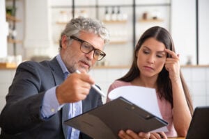 Why Two Hours in Custody Can Be Worth Six Figures: How Damages Work in a Civil Rights Case 2 Legal advisor reviewing and explaining documents to a female client during a consultation.