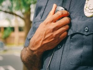 Why the California Bane Act Is a Powerful Tool in Police Cases and How to Prove It 2 Police officer using a shoulder radio while on duty outdoors.