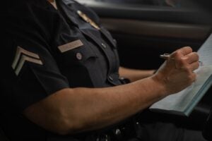 Can You Sue the Police for Negligence in California? 1 Police officer writing notes in a report while on duty.